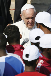 Pope Francis talks with immigrants at the port in Lampedusa, Italy, on July 8, 2013.  The Pope called for repentance over treatment of migrants as he visited the Italian island where massive numbers of Africans have landed in attempts to reach Europe (CNS photo/Paul Haring).