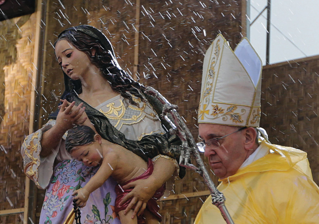 Rain falls as Pope Francis walks past a statue of Mary and the Christ child as he celebrates Mass adjacent to the airport in Tacloban, Philippines. 