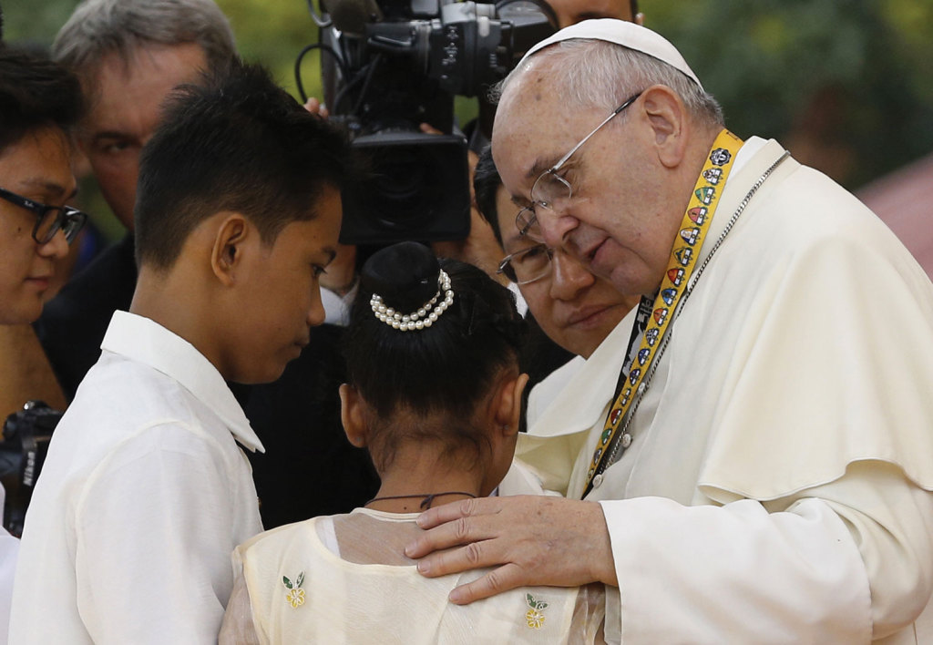 Pope Francis greets Jun Chura, 14, and Glyzelle Palomar, 12, two former street children who spoke during a meeting with young people at the University of St. Thomas in Manila, Philippines. 
