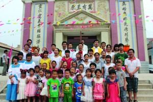Children gather with parish priests for a photo on the steps of Sacred Heart of Jesus Church in the village of Fufengxian, in China's Shaanxi province, in late July. The Catholic parish was marking its 17th anniversary in a region known for its apple groves. (CNS photo) (Aug. 23, 2013) See CHINA-VILLAGE Aug. 23, 2013.