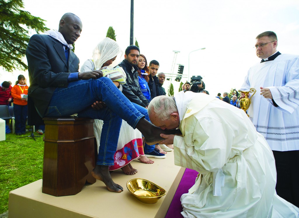 Pope Francis kisses the foot of a refugee during Holy Thursday Mass of the Lord's Supper at the Center for Asylum Seekers in Castelnuovo di Porto, about 15 miles north of Rome March 24. The pope washed and kissed the feet of refugees, including Muslims, Hindus and Copts. (CNS photo/L'Osservatore Romano, handout) See POPE-MASS-REFUGEES March 24, 2016.