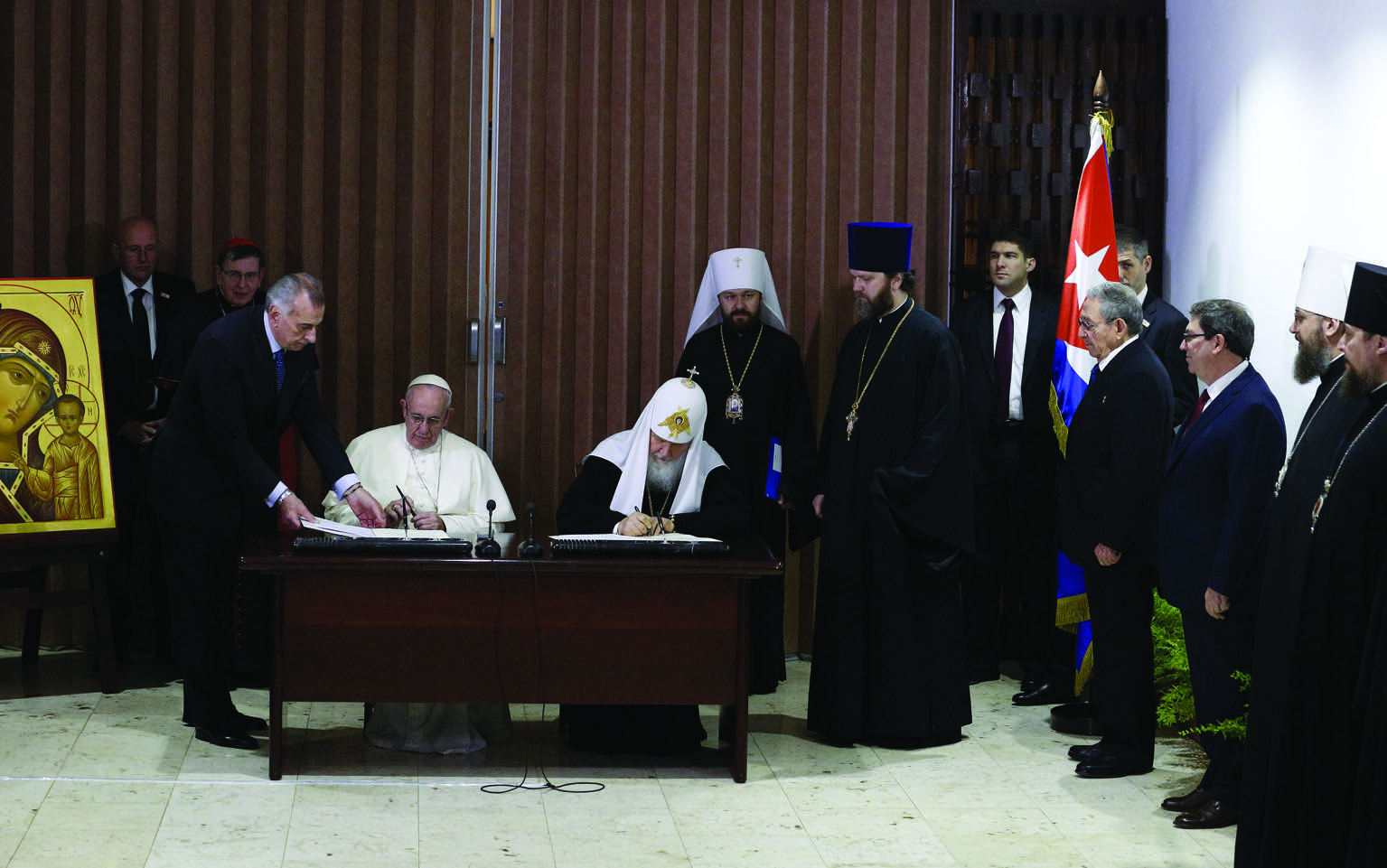 Pope Francis and Russian Orthodox Patriarch Kirill of Moscow sign a joint declaration during a meeting at Jose Marti International Airport in Havana Feb. 12. Standing in front of Cuba's flag is Cuban President Raul Castro. (CNS photo/Paul Haring) See POPE-PATRIARCH-CUBA Feb. 12, 2016.
